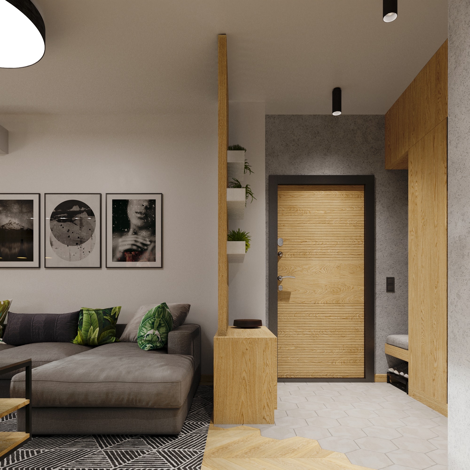 Wnętrze mieszkania z szarą sofą z poduszkami w liście, trzema obrazami w czarnych ramkach, drewnianą ścianką działową z półkami na rośliny, drewnianymi drzwiami wejściowymi i szafą w przedpokoju.