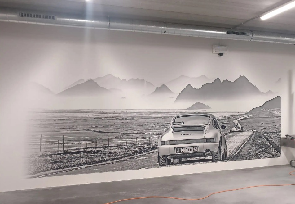 Czarno-biały druk wielkoformatowy na ścianie przedstawiający Porsche Carrera 4 na tle górskiego krajobrazu z drogą