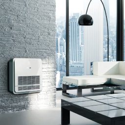 Spooko.pl Klimatyzacja Pompy Ciepła - Biały klimatyzator ścienny z widocznymi żaluzjami w nowoczesnym wnętrzu z ceglaną ścianą, panoramicznym oknem z widokiem na miasto i designerską lampą łukową.