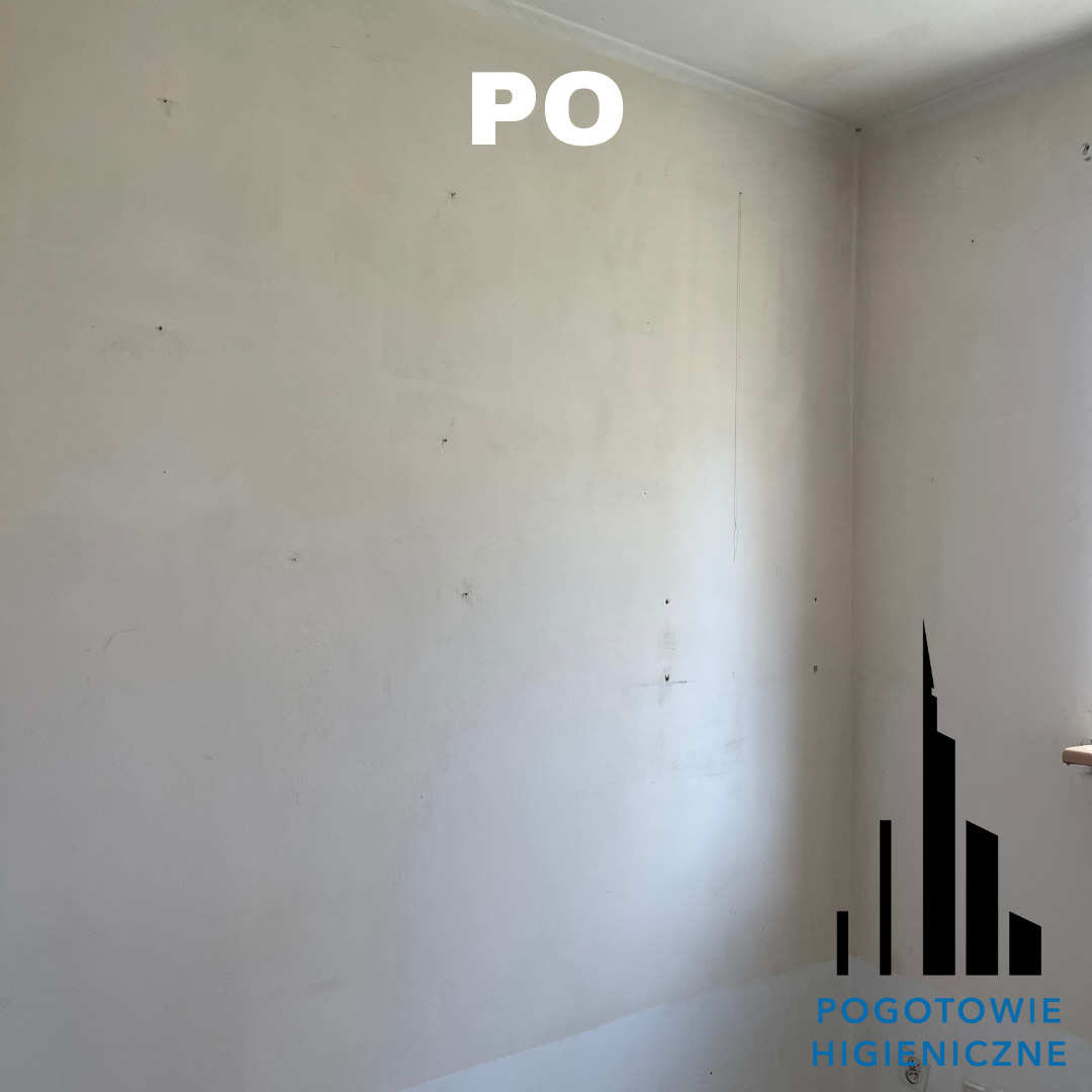 Biała ściana w rogu pomieszczenia po usunięciu zabrudzeń, z widocznym logo firmy świadczącej usługi higieniczne w prawym dolnym rogu i napisem 'PO' na górze zdjęcia.
