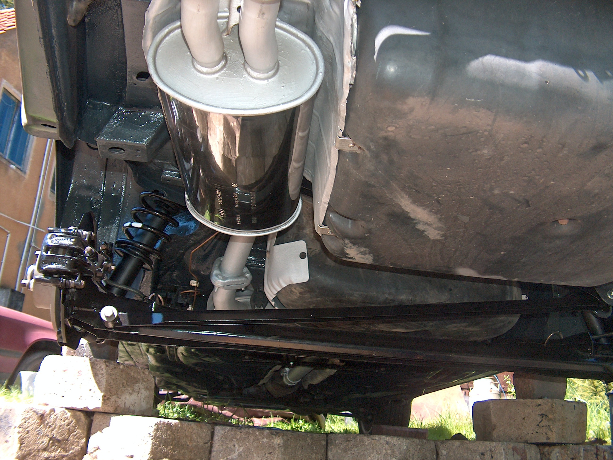 Podwozie auta po konserwacji antykorozyjnej w Jonkowie: nowy układ wydechowy, czarne elementy zawieszenia, widoczne ślady spawania na elementach nośnych.