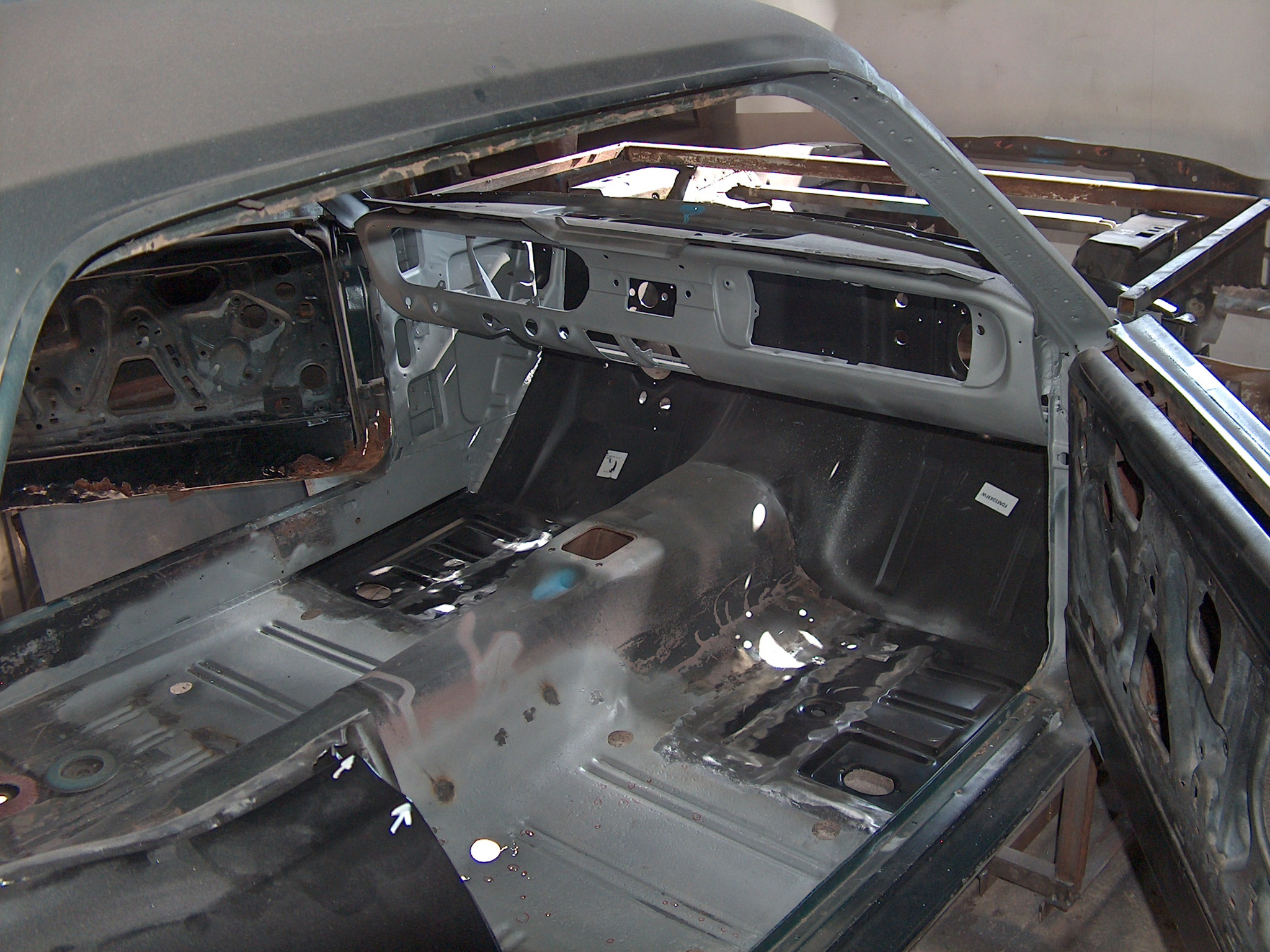 Wnętrze odrestaurowywanego samochodu: goła blacha, widoczne ślady spawania, przygotowane do dalszych prac konserwatorskich. Detal deski rozdzielczej i podwozia.