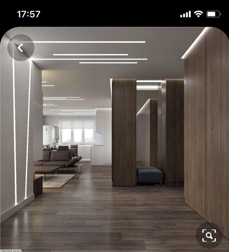 Nowoczesne wnętrze mieszkania z drewnianą podłogą, oświetleniem LED w suficie i ścianach oraz zabudową z forniru.