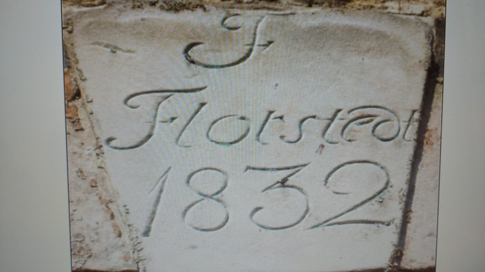 Wyryty w kamieniu napis 'Forstedt 1832' z ozdobną literą 'F', umieszczony na tle muru.