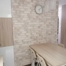 Montaż płytki gipsowej na ścianie z supereksu.