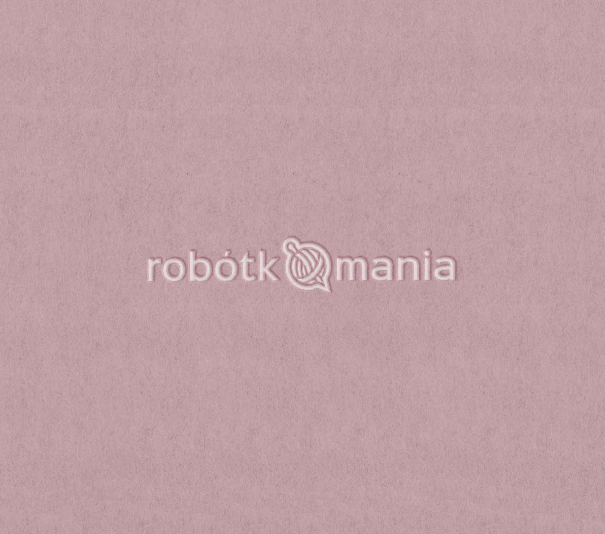 Teksturowane, pudrowo-różowe tło z wytłoczonym, jasnym logo 'robotkomania' pośrodku.