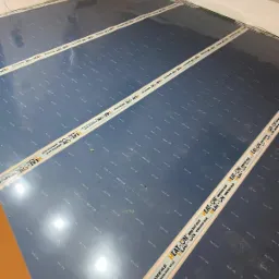 Rozłożone maty grzewcze HEAT-ON na podłodze, widoczne przewody i oznaczenia producenta, przygotowane do montażu w systemie ogrzewania podłogowego.