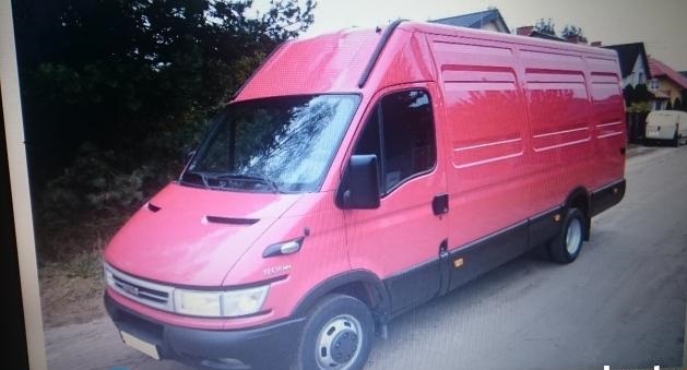 Różowy samochód dostawczy Iveco Daily z wysokim dachem zaparkowany na podjeździe przed domem.