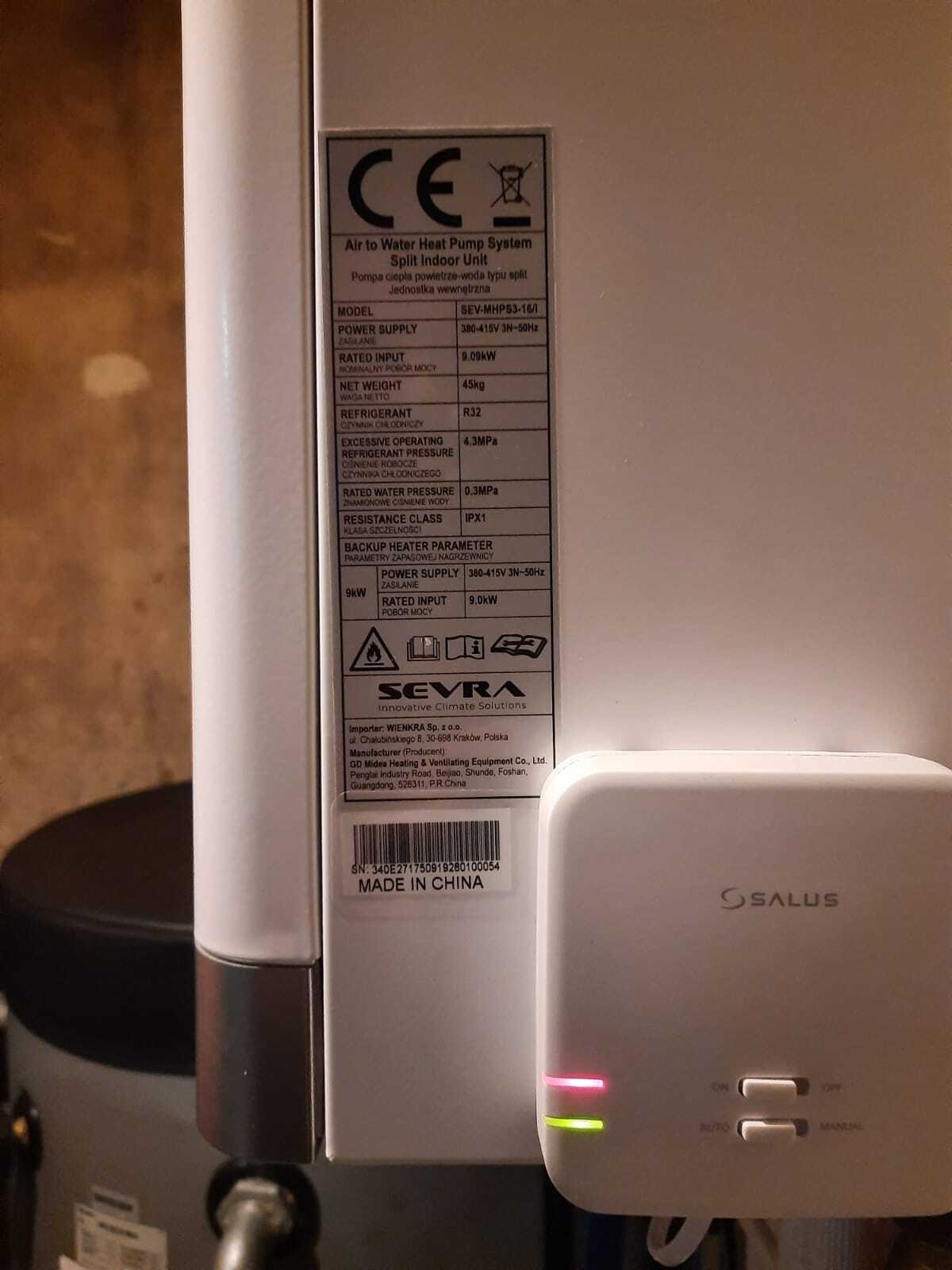 Etykieta znamionowa pompy ciepła powietrze-woda SEVRA z widocznymi parametrami technicznymi oraz sterownik SALUS z diodami sygnalizacyjnymi.