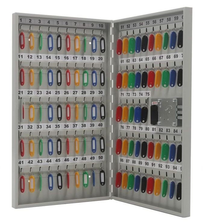 Otwarta szafka na klucze z ponumerowanymi haczykami i kolorowymi breloczkami do kluczy, widoczny zamek.