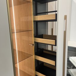 Mark Pol Meble - Otwarta szafa wnękowa z oświetleniem LED i drewnianymi półkami, widok z boku. Szklane półki wewnątrz. Minimalistyczny design.