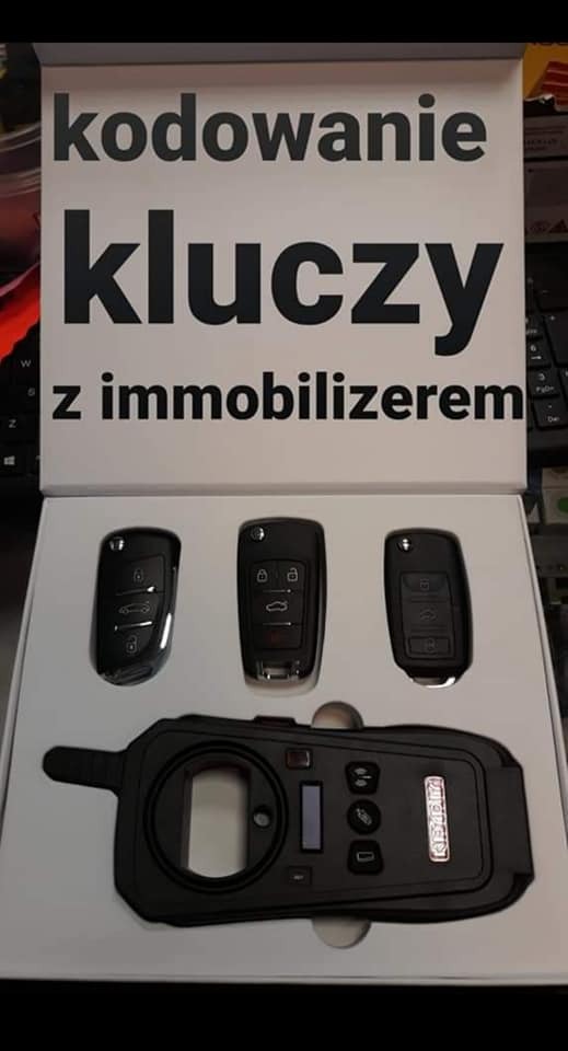 Kodowanie kluczy samochodowych z immobilizerem: trzy klucze i programator w białym pudełku na biurku.