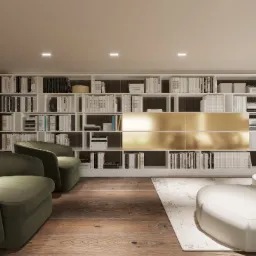 Salon z dużą białą biblioteczką, złotymi akcentami, dwoma zielonymi fotelami i kremową sofą na wzorzystym dywanie.