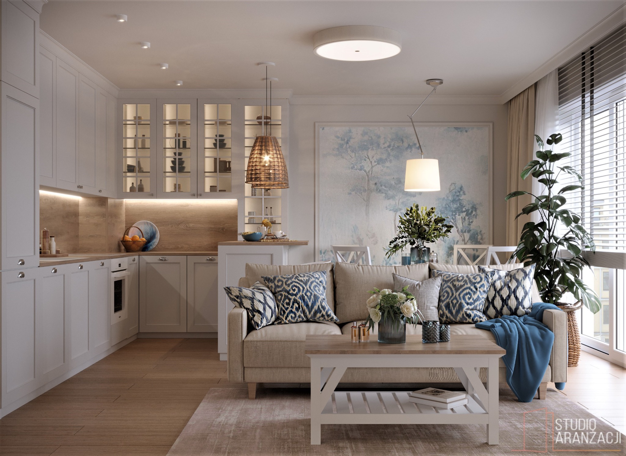 Jasne wnętrze: salon z aneksem kuchennym, beżowa sofa z wzorzystymi poduszkami, drewniany stolik kawowy, na ścianie obraz w błękitnych tonacjach, wisząca lampa z plecionki, duża roślina doniczkowa...