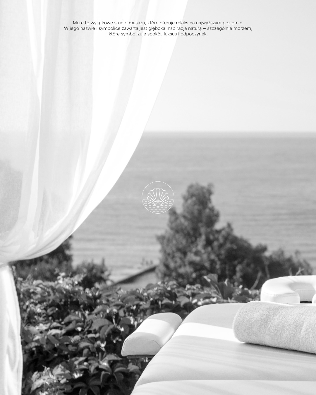 Czarno-białe zdjęcie wnętrza studia masażu w Lubinie, z widokiem na morze przez okno, zasłonięte delikatną, białą firanką. Na pierwszym planie leżanka do masażu z ręcznikiem. W tle widoczny ogród...