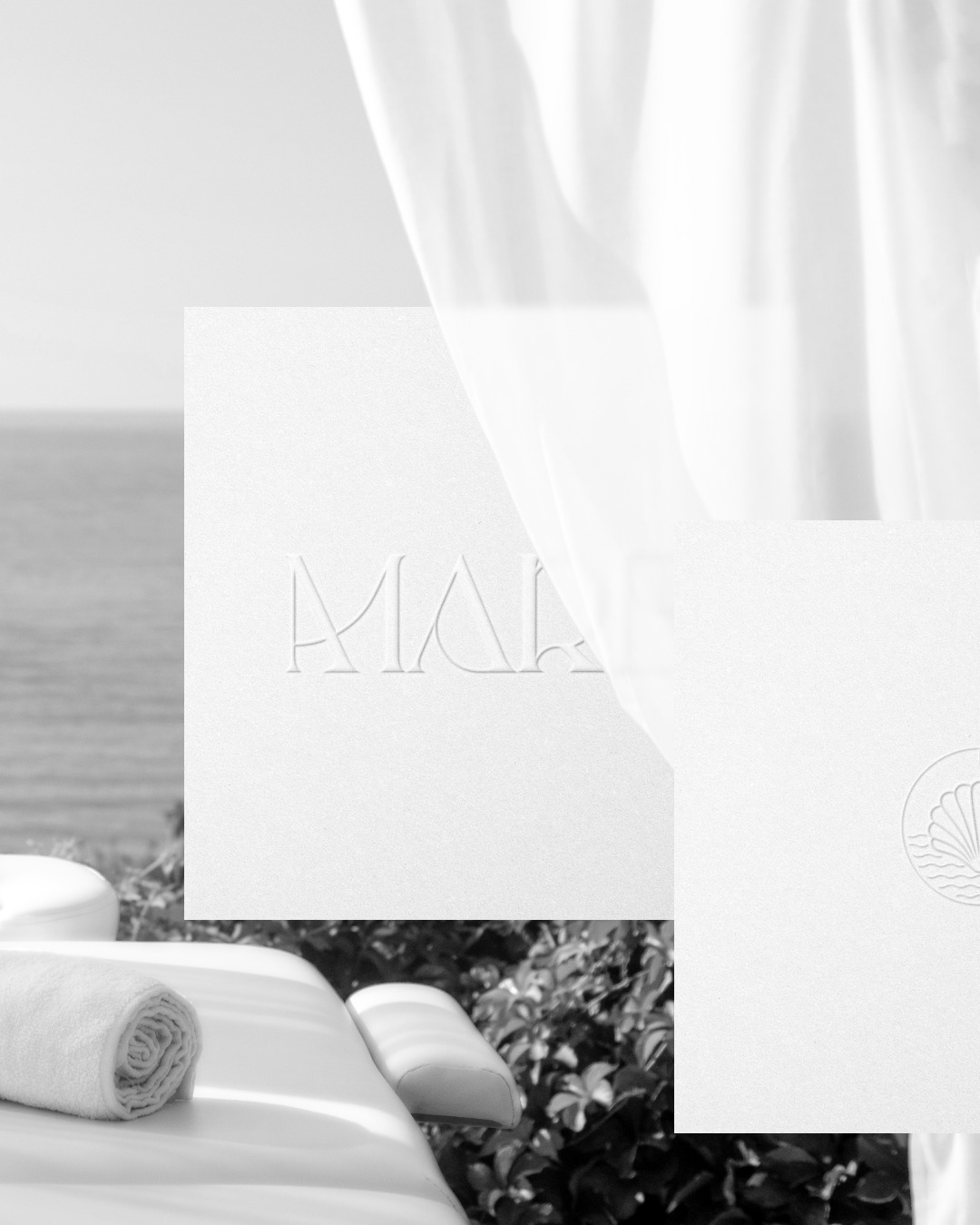Monochromatyczna kompozycja z logo wytłoczonym na papierze, leżący ręcznik na leżance, morze w tle i zwiewna zasłona.