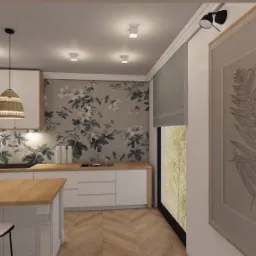 Wizualizacja kuchni z wyspą, drewnianym blatem, białymi szafkami i lampami z abażurami z naturalnego materiału. Na ścianie tapeta w kwiaty i obraz z motywem liścia.