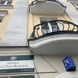 Elewacja kamienicy z balkonami i szyldem informującym o kancelarii adwokackiej Jacek Paweł Kamiński, numer budynku 24, Rynek Kościuszki.