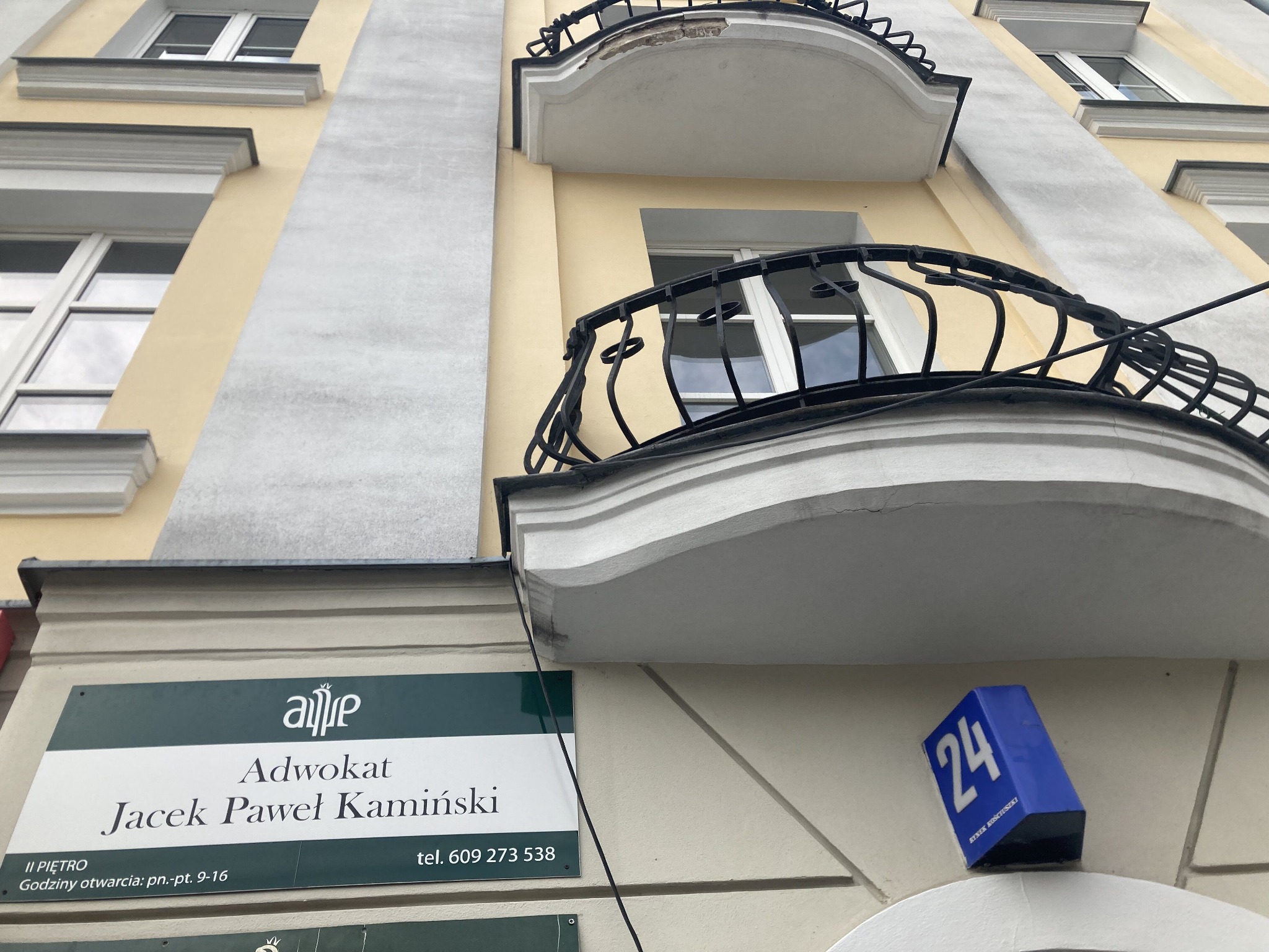 Elewacja kamienicy z balkonami i szyldem informującym o kancelarii adwokackiej Jacek Paweł Kamiński, numer budynku 24, Rynek Kościuszki.
