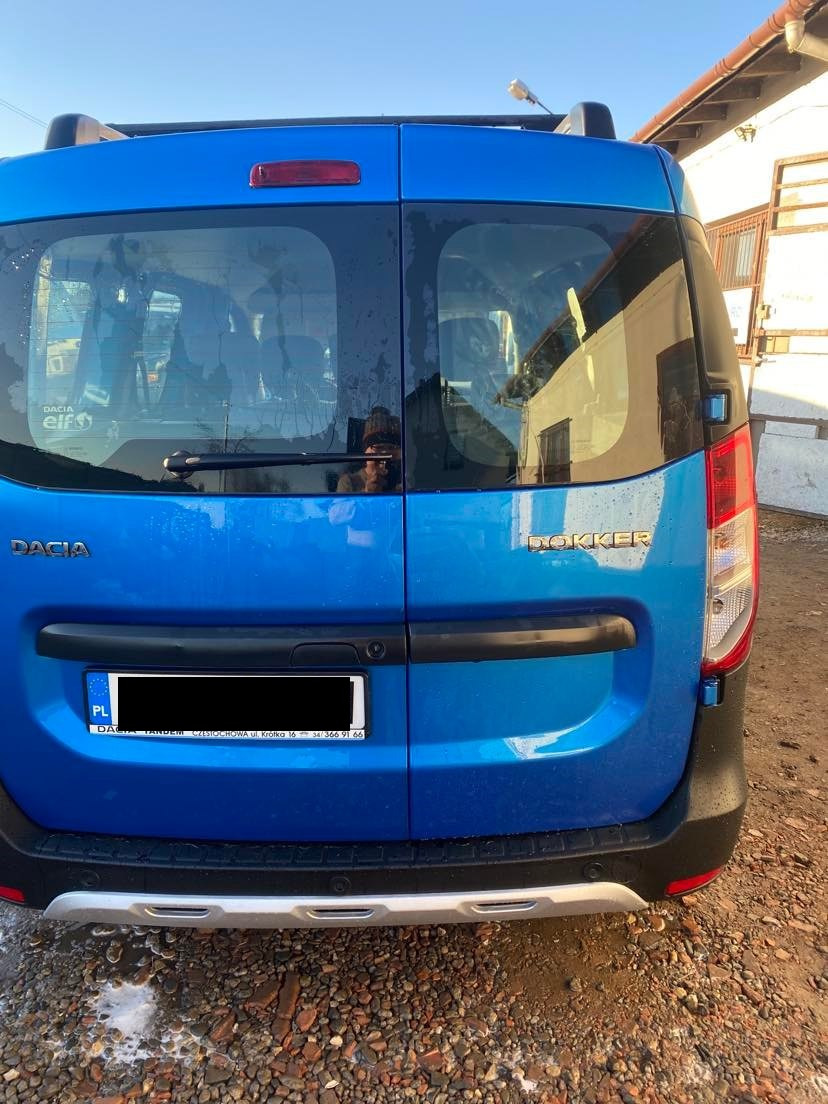 Niebieski samochód dostawczy Dacia Dokker z tyłu, zaparkowany w Częstochowie na żwirowym podłożu, widoczna naklejka Dacia Elf na szybie.