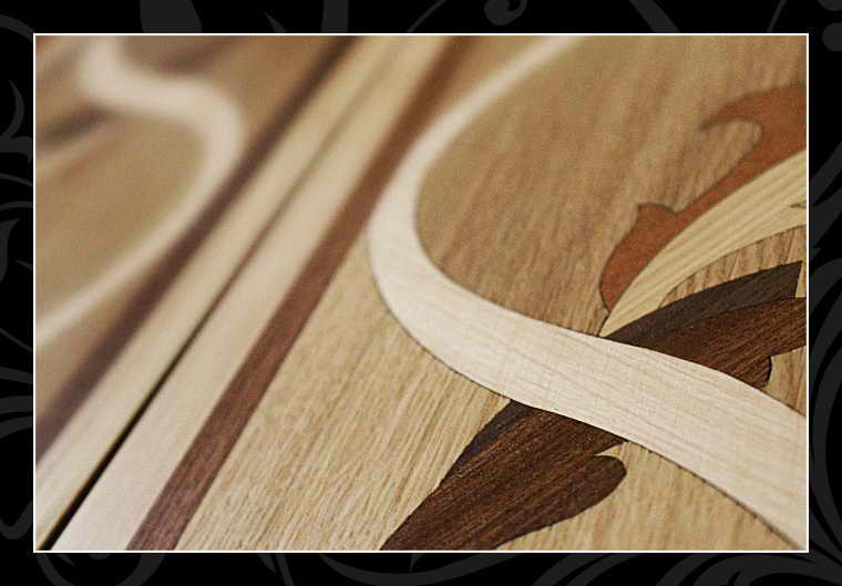 Detal pałacowej podłogi z intersją, ukazujący precyzyjne połączenie różnych gatunków drewna tworzących dekoracyjny wzór.