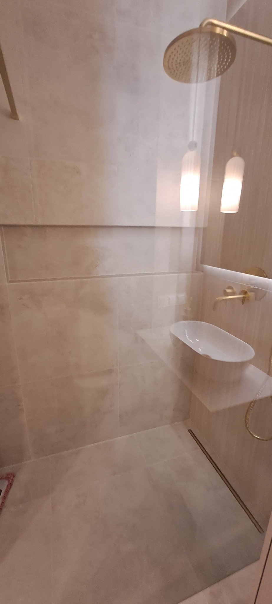 Beżowa łazienka z kabiną typu walk-in, deszczownicą i umywalką nablatową. Minimalistyczny design z akcentami w kolorze złota.