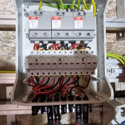 Solgreen - Rozdzielnica elektryczna z zabezpieczeniami przepięciowymi, zamontowana na szynie, z puszką Red Bull The Winter Edition stojącą obok.