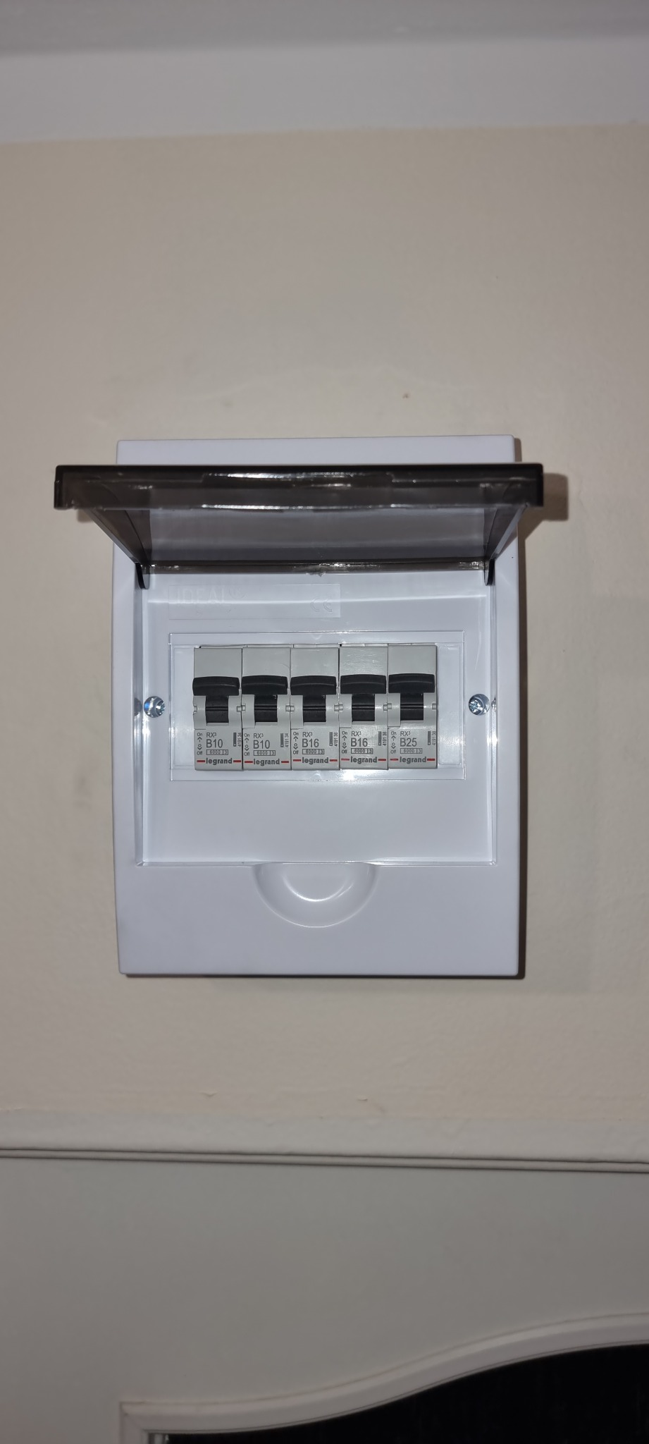 Otwarta skrzynka bezpiecznikowa Legrand z wyłącznikami B10, B16 i B25 zamontowana na ścianie.