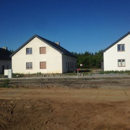 DAPO Firma Ogólnobudowlana - Nowe domy jednorodzinne w trakcie budowy, widoczne niedokończone elewacje i przygotowany teren.