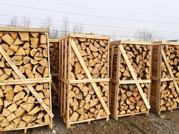 Ułożone w drewnianych skrzyniach pocięte kawałki drewna opałowego, widok z bliska na składzie.