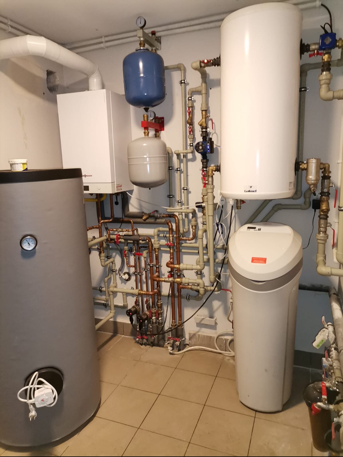 Kompaktowa kotłownia z piecem gazowym, zasobnikiem ciepłej wody, naczyniami wzbiorczymi i filtrem wody, liczne rury miedziane i z tworzywa sztucznego z zaworami odcinającymi, manometry...