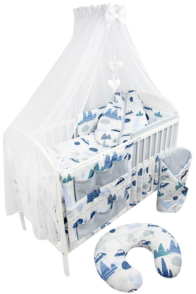 Białe łóżeczko dziecięce z baldachimem i kompletem pościeli w motywy samochodów i drzew, dodatkowo poduszka rogal do karmienia w tym samym wzorze.