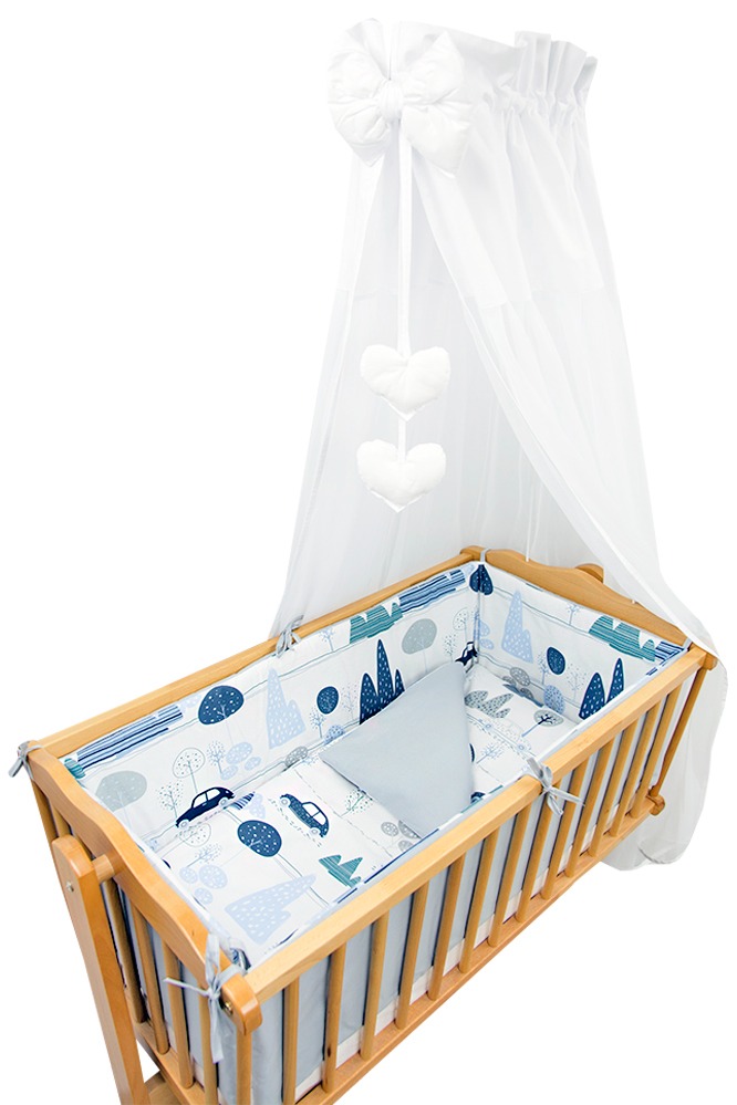 Drewniane łóżeczko dziecięce z baldachimem i pościelą w motywy samochodów i drzew, widok z góry na białym tle.