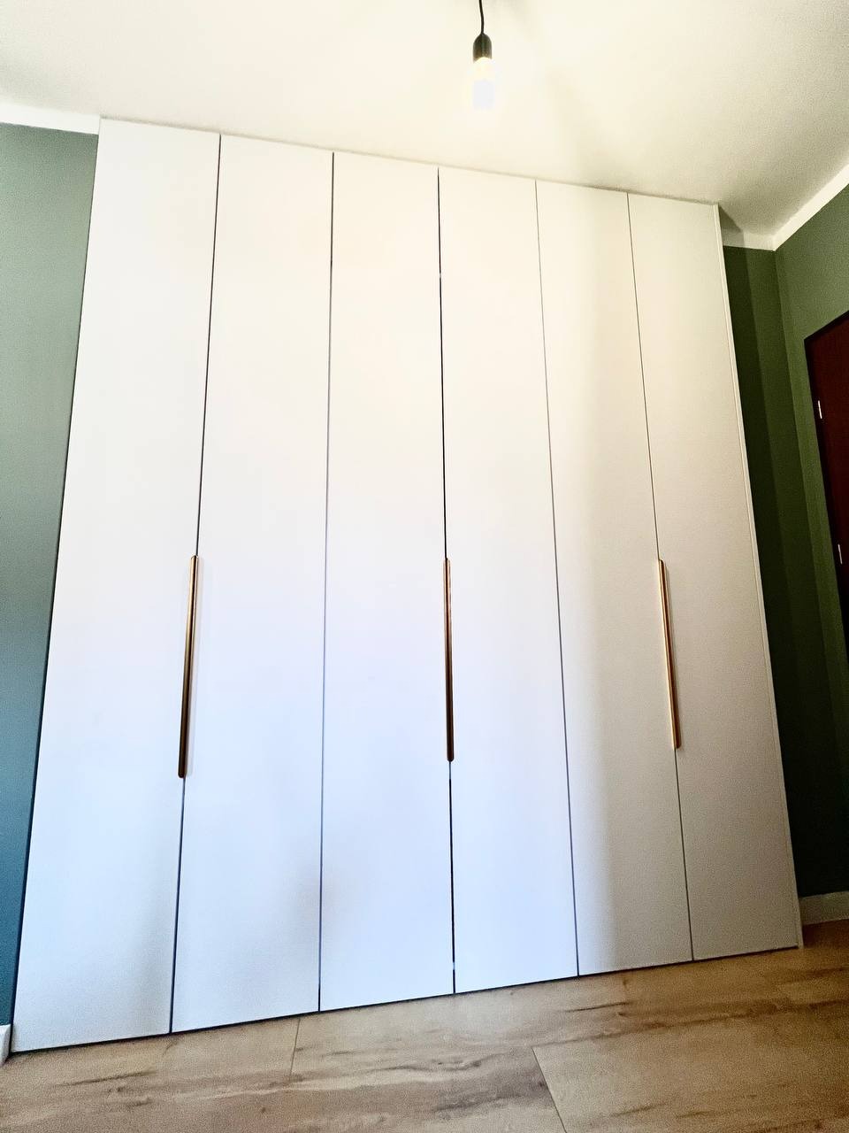 Szafa wykonana z płyty Pfleiderer U11027. Z miejscem na drążki, szuflady oraz deskę do prasowania i żelazko.