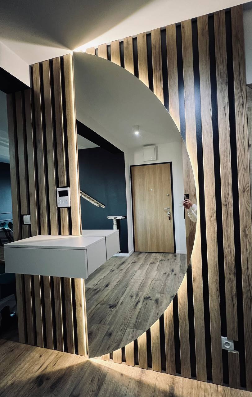 Owalne lustro na ścianie z lamelami