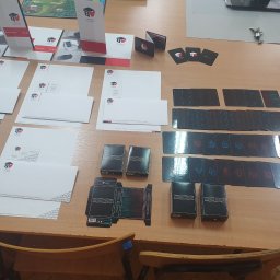 Surton Design - Stół z rozłożonymi elementami identyfikacji wizualnej firmy Thirteen Hearts, w tym wizytówki, papier firmowy, ulotki, oraz talie kart do gry Star Wars w czarnych pudełkach i rozłożone karty...