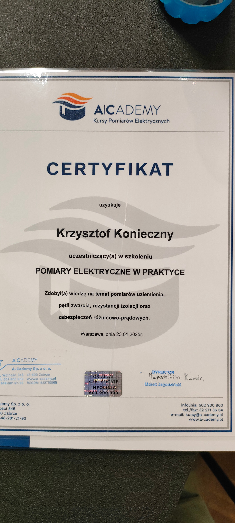 Certyfikat ukończenia szkolenia z zakresu pomiarów elektrycznych w praktyce, wydany przez AICADEMY, z hologramem potwierdzającym autentyczność i podpisem dyrektora Marka Jagodzińskiego.