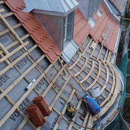 WTTW (Witalij Tseluiko Tinsmith Workshop). - Montaż łat i kontrłat na membranie dachowej, przygotowanie pod dachówkę karpiówkę, widoczne okna dachowe z blachy, narzędzia pracy i fragment rynny.