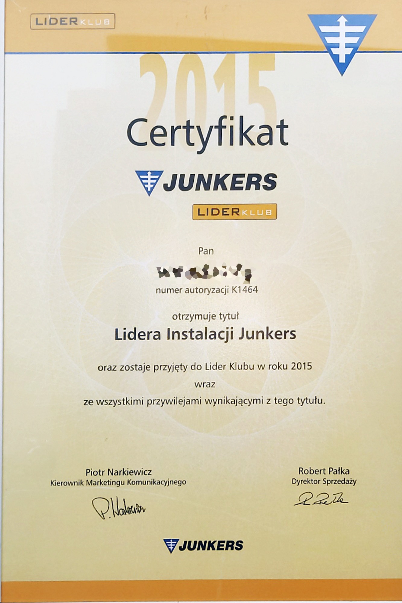 Skan certyfikatu Lidera Instalacji Junkers z 2015 roku, z numerem autoryzacji K1464, podpisany przez Piotra Narkiewicza i Roberta Pałkę.