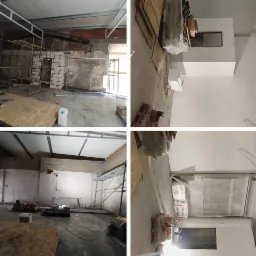 Wnętrze w trakcie remontu: surowe ściany z fragmentami cegieł, metalowe rusztowania, płyty OSB na podłodze, worki z materiałami budowlanymi i białe pojemniki z klejem.