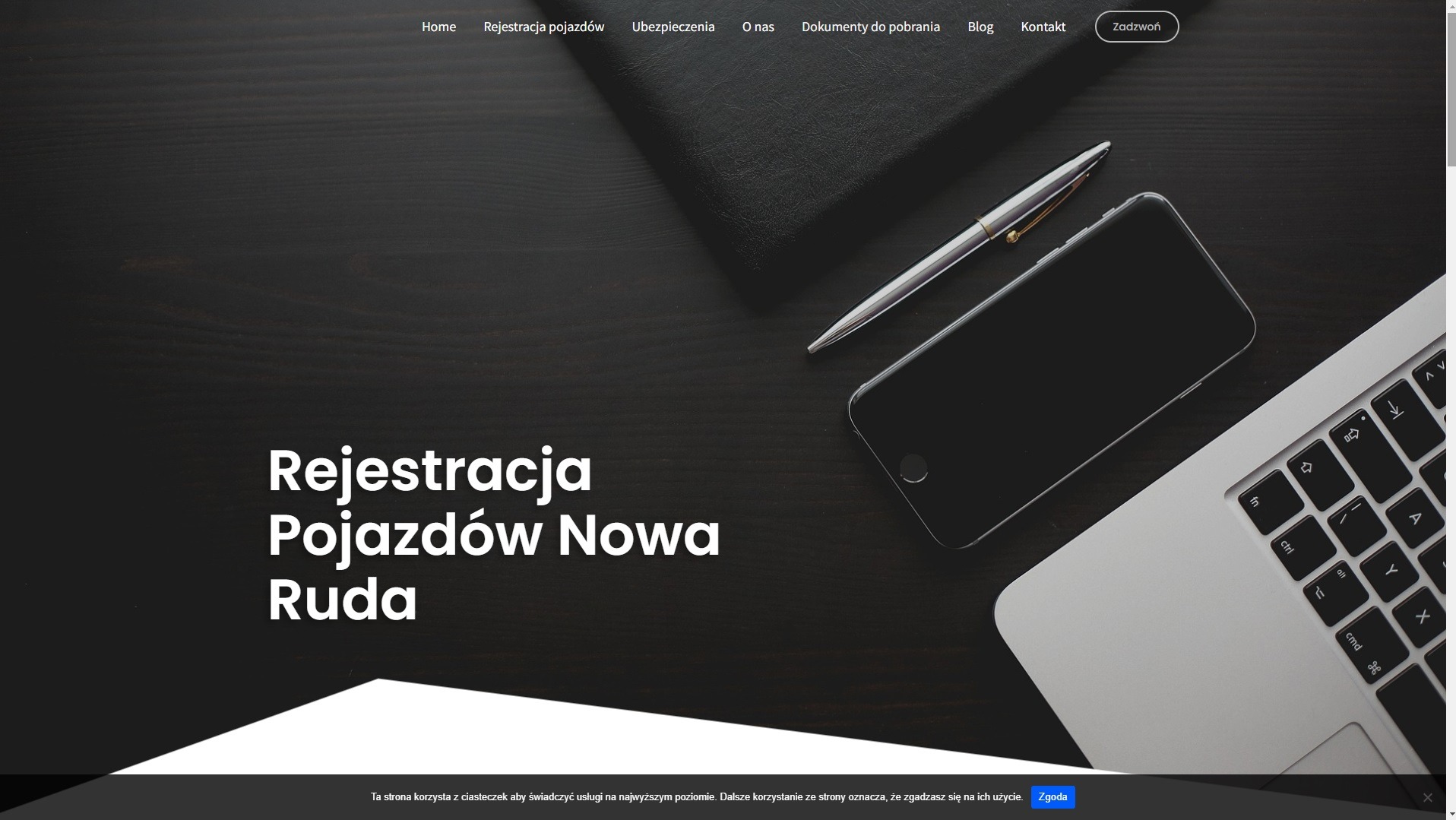 Strona internetowa z nagłówkiem 'Rejestracja Pojazdów Nowa Ruda', widoczny laptop, długopis i smartfon na ciemnym, drewnianym tle.