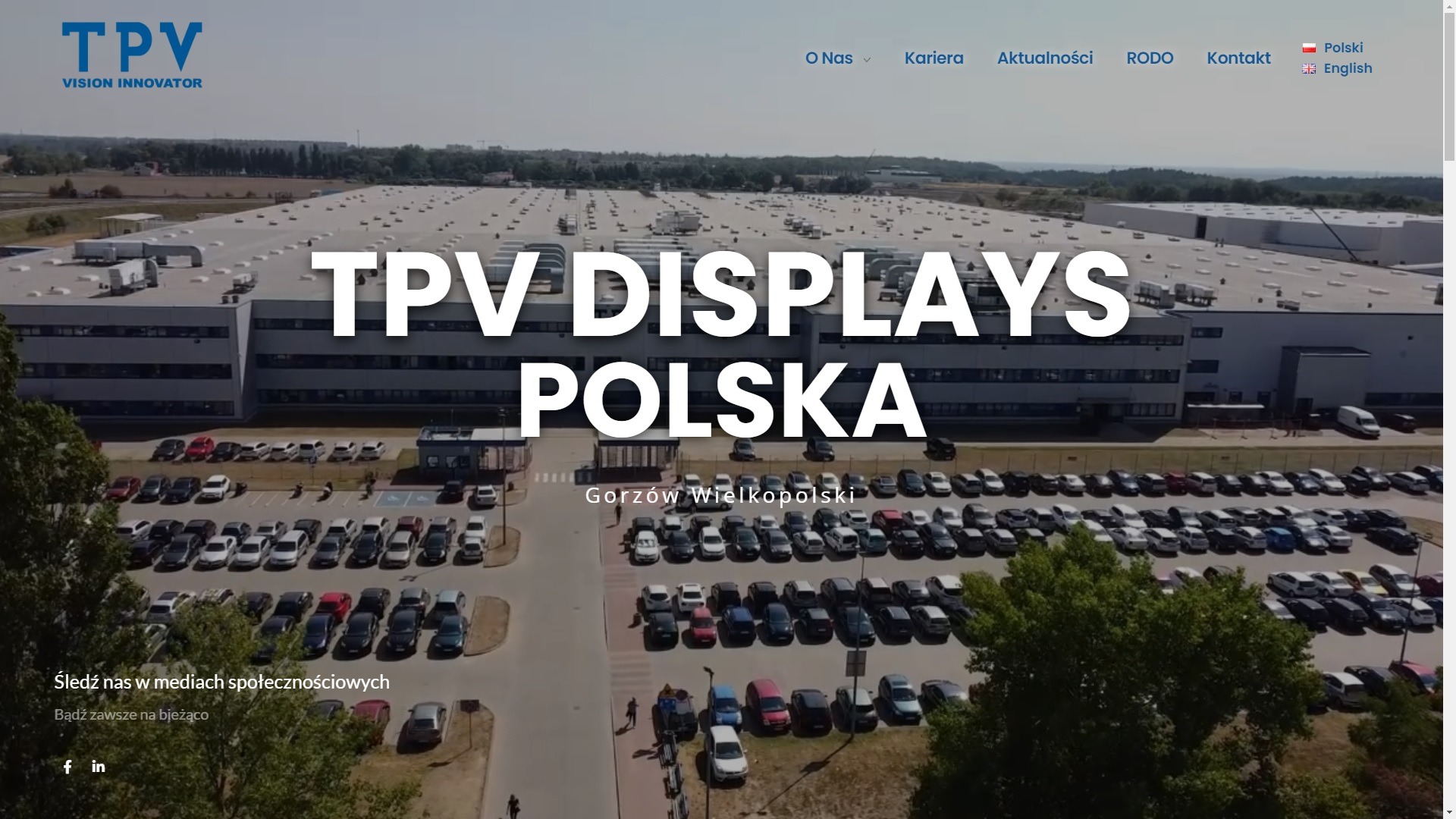 Zdjęcie z lotu ptaka przedstawiające budynek fabryki TPV Displays Polska z parkingiem pełnym samochodów w Gorzowie Wielkopolskim.