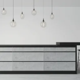 Wizualizacja minimalistycznej kuchni z szarą wyspą i czarnymi hokerami pod wiszącymi szklanymi lampami z żarówkami Edisona.