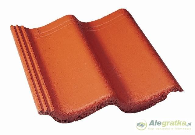 Pojedyncza dachówka cementowa w odcieniu terakoty, widoczna z góry na białym tle, prezentująca swój profil falisty i teksturę powierzchni.