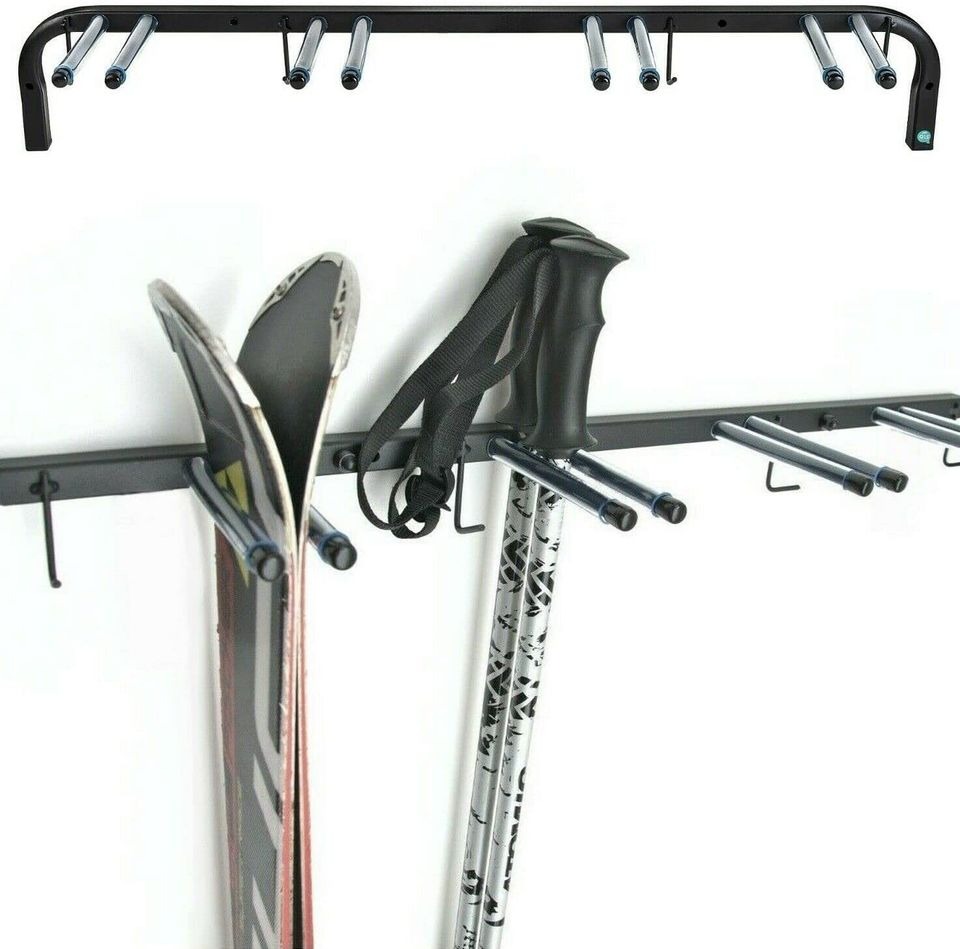 Metalowy wieszak ścienny na narty i kijki narciarskie z widocznym mocowaniem do ściany.