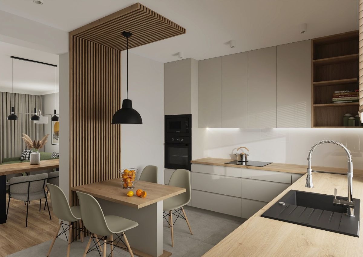Nowoczesna kuchnia w odcieniach beżu i drewna, z drewnianą ścianką działową i stołem z owocami, minimalistyczne oświetlenie, widok na salon w tle.