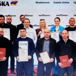 Grupowe zdjęcie instruktor&oacute;w z dyplomami na tle logotypu Gazety Wrocławskiej, prawdopodobnie po wręczeniu nagr&oacute;d.