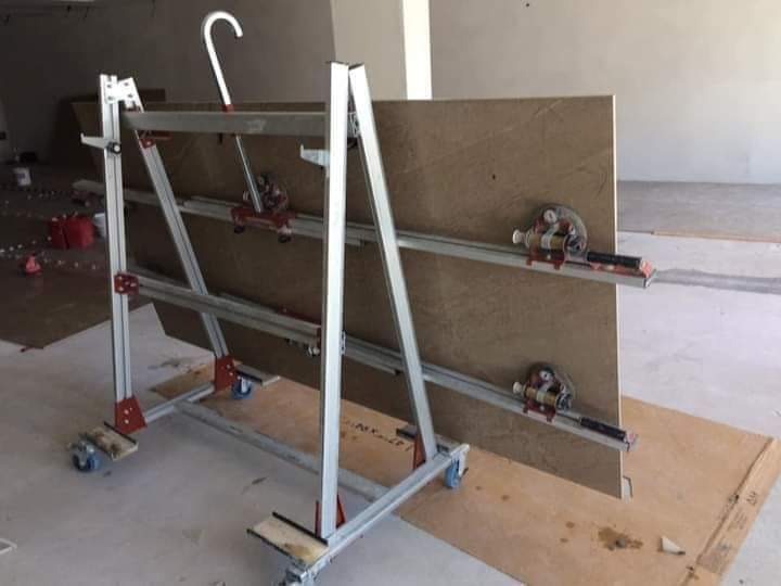 Profesjonalna przecinarka do płytek wielkoformatowych z zamocowaną płytą w trakcie pracy, widoczne przyssawki mocujące i metalowa konstrukcja na kółkach.