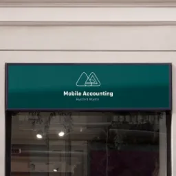 Szyld reklamowy 'Mobile Accounting Ryszard Wydro' z minimalistycznym logo na zielonym tle, umieszczony nad witryną.