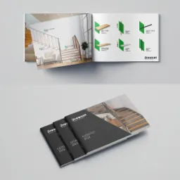 Otwarty katalog firmy DrewNet z wizualizacjami schodów i elementów wykończeniowych, obok trzy zamknięte katalogi z rocznikiem 2022.